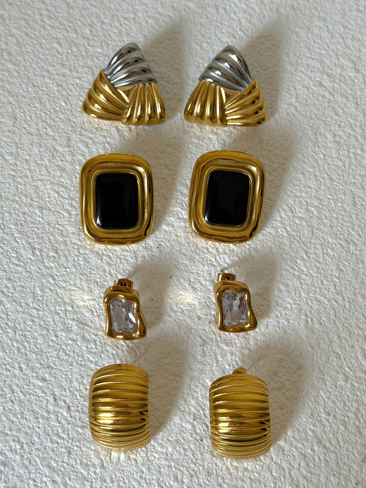 Two-Toned Knot Studs, Noire Onyx Studs, Molten CZ Stone Earring and Grooved 3/4 Hoops laid flat (placeholder for The Ear Edit)